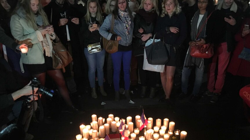 People stand around candles at a vigil for Nice at Circular Quay in Sydney.