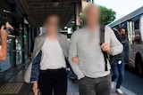 Two people with faces blurred