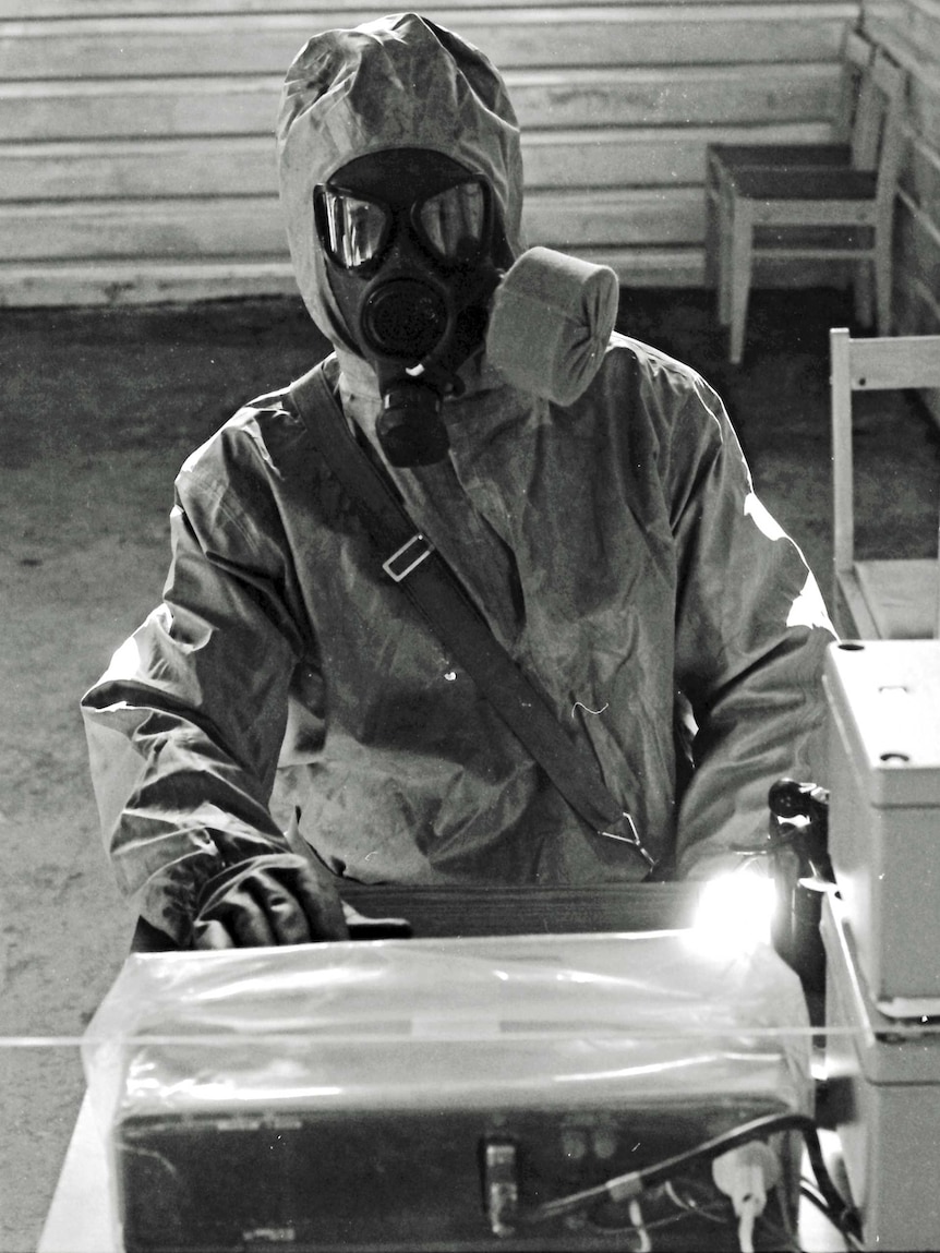 In this Oct. 4, 1987 file photo, a Soviet army serviceman in protective suit handles toxic substances.