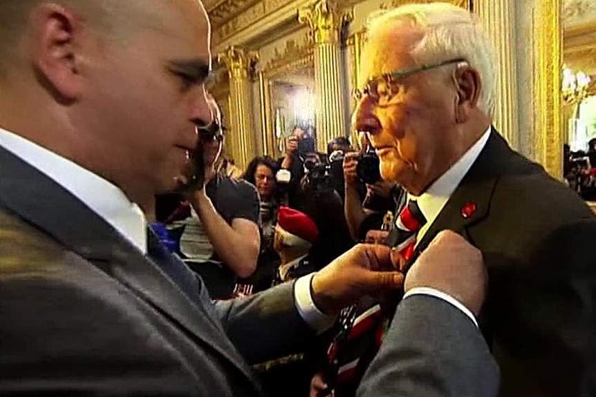 Bill Evans receives his Legion of Honour during a ceremony in the town of Caen in Normandy.