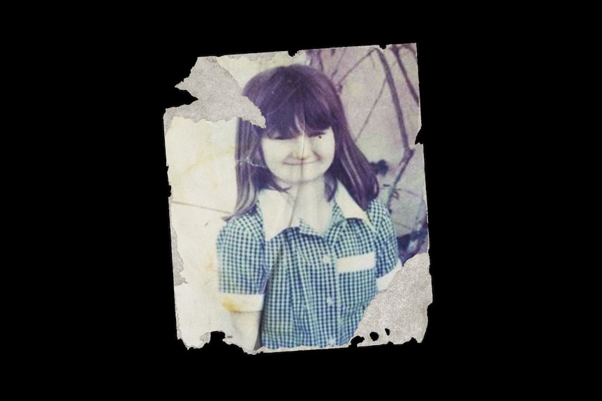 A torn photograph of a young girl.