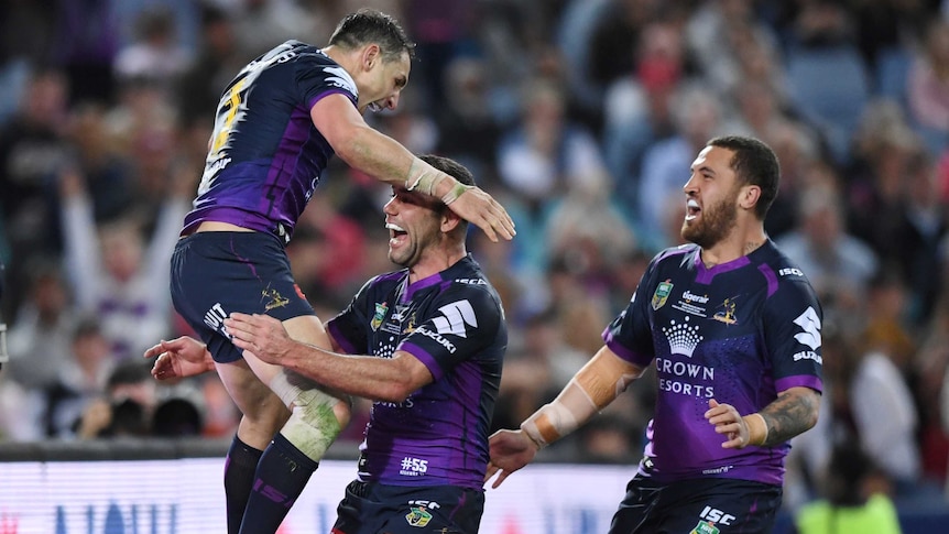 Billy Slater jumps on Cameron Smith in celebration of a try.