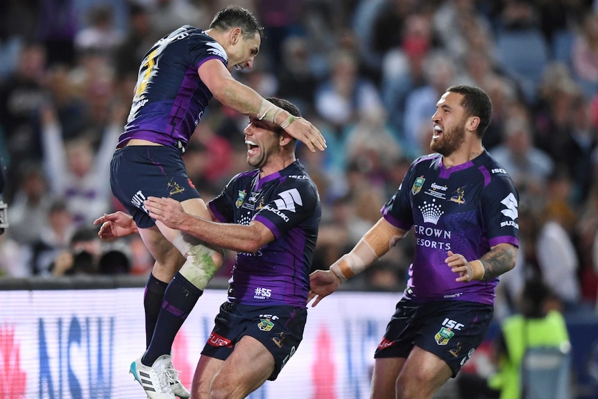 Billy Slater jumps on Cameron Smith in celebration of a try.