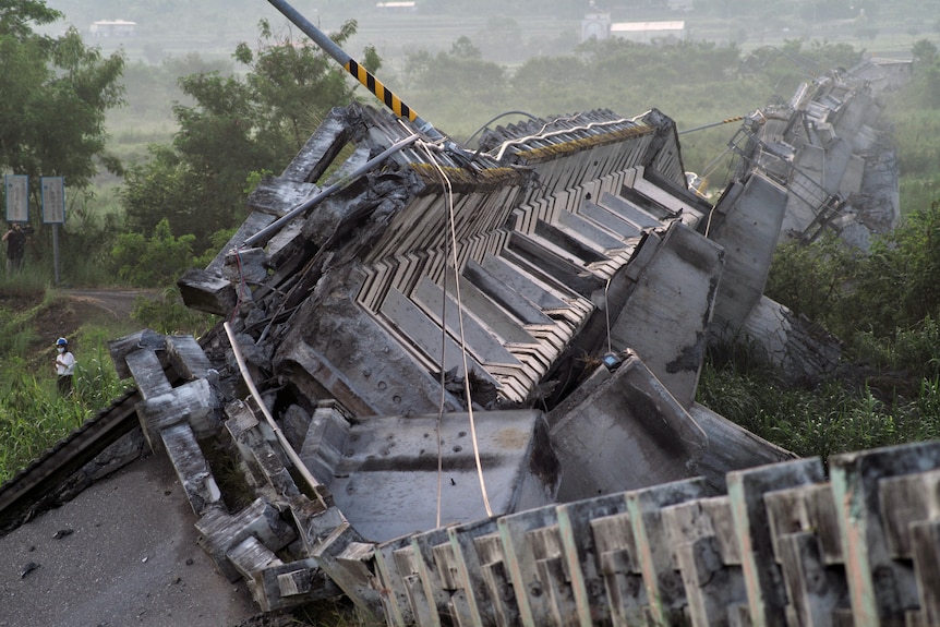 A cement bridge has fallen onto its side. 