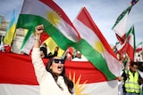 People protest holding Iranian and Kurdish flags in London.