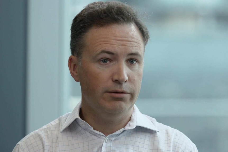 Head shot of Andy White of the Australian Payments Network sitting at a table in his office