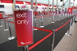 An exit only sign in front of an empty Virgin Australia check-in area.