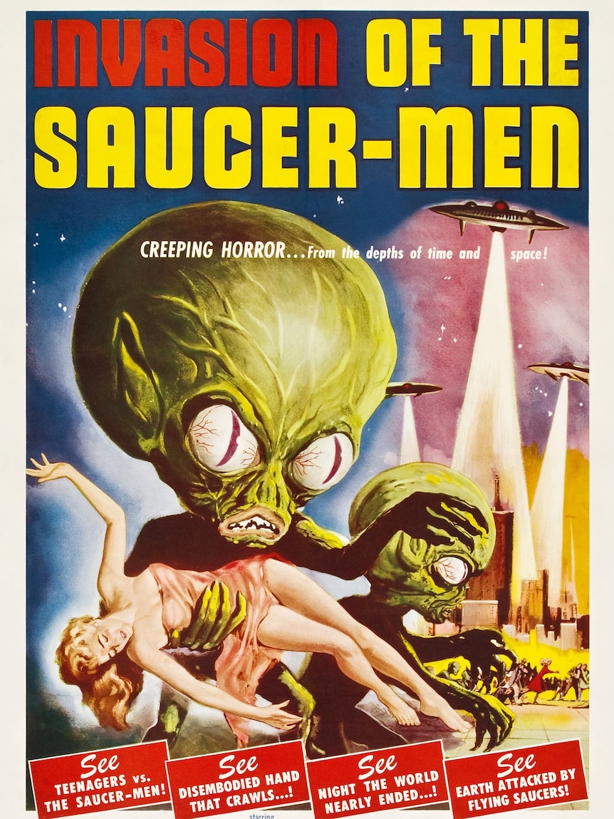 A 1950s film poster of 'Invasion of the Saucer-men' featuring aliens with large green heads grabbing a woman