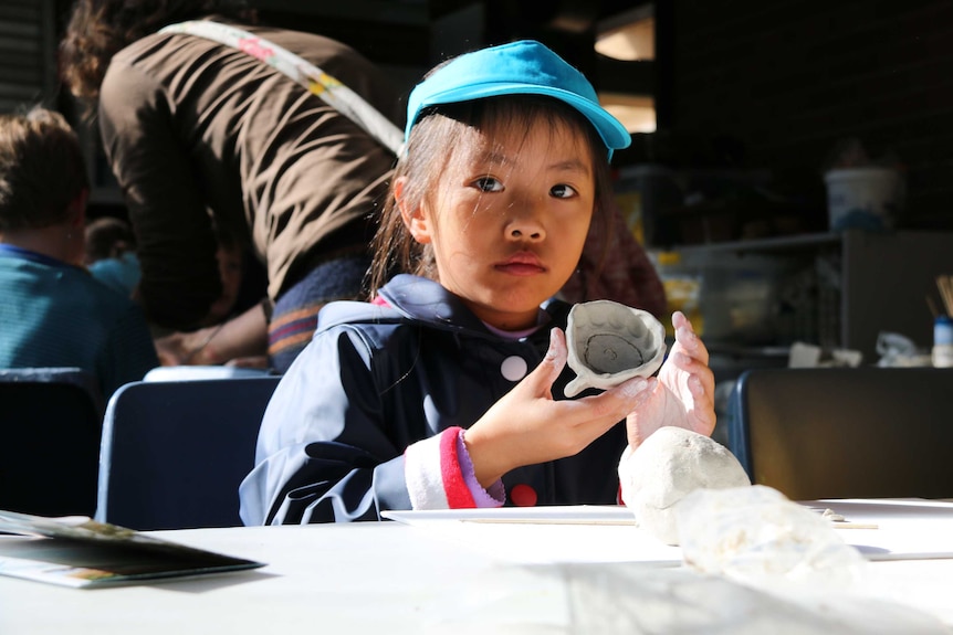 A girl making clay statues at the National Botanic Gardens in Canberra.