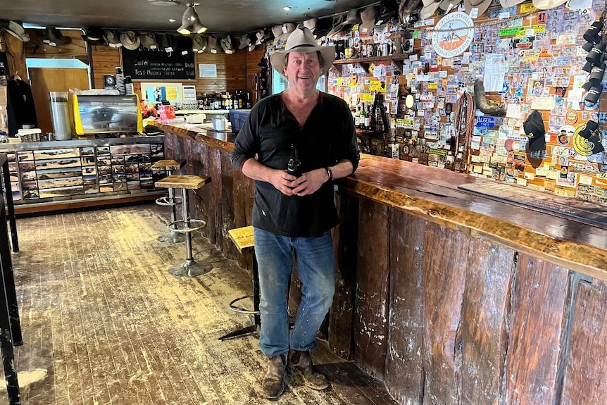 A man in a hat near a bar.