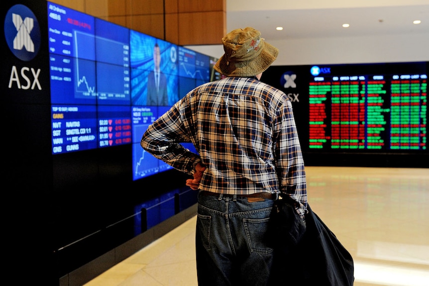 An elderly man watches the share market prices at the Australian Stock Exchange in Sydney.