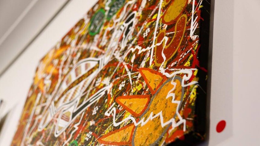 Close up picture of an Indigenous artwork painted for an exhibition, with a red dot next to it