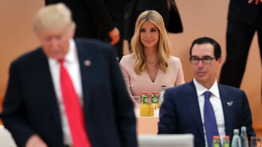 A seated Ivanka Trump in centre of frame with her father Donald to her right