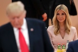 A seated Ivanka Trump in centre of frame with her father Donald to her right