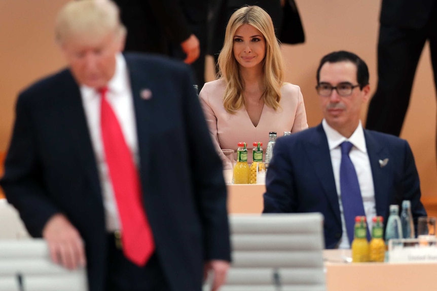 A seated Ivanka Trump in centre of frame with her father Donald to her right