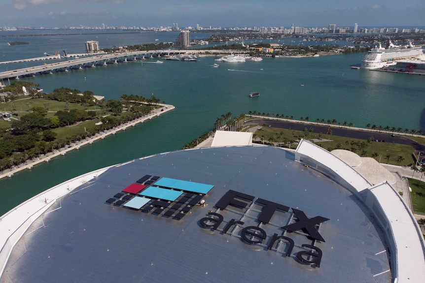 An aerial photograph of the Miami shoreline shows the FTX Arena logo prominently on top of a stadium.