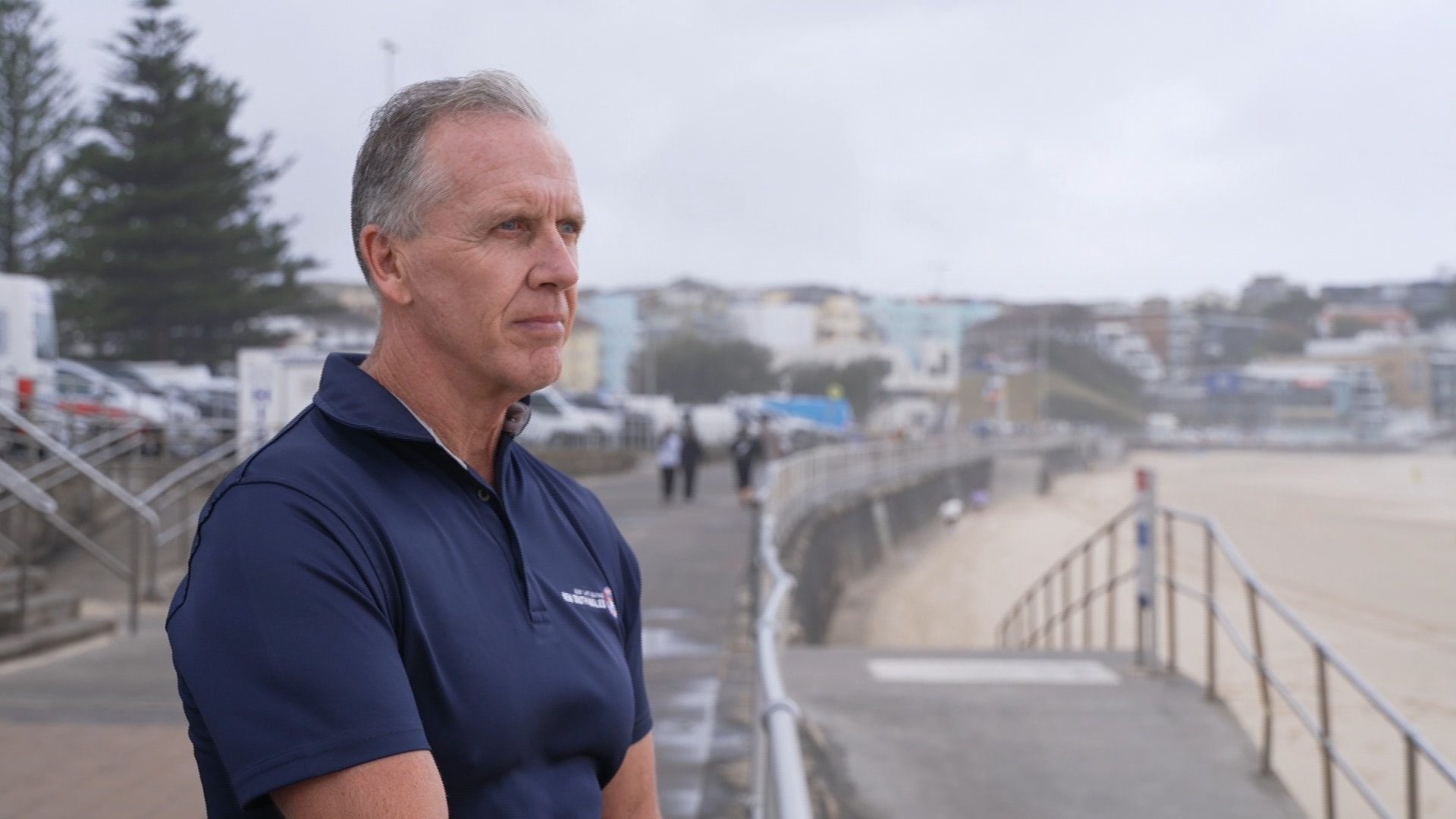 Steve Pearce mira a Bondi Beach con expresión seria.