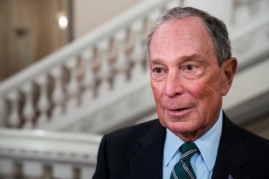 Michael Bloomberg stands outside a building