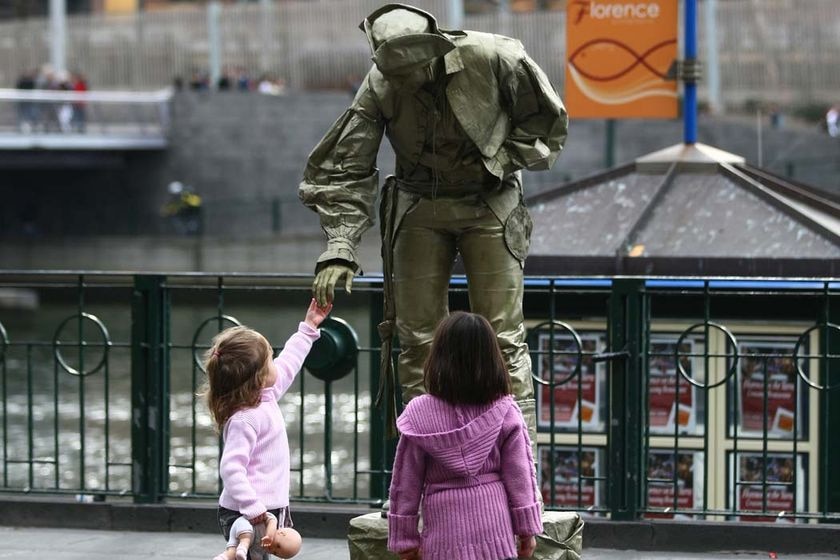 Curious minds examine street performer