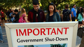 CUSTOM IMAGE of people looking at US government shutdown sign