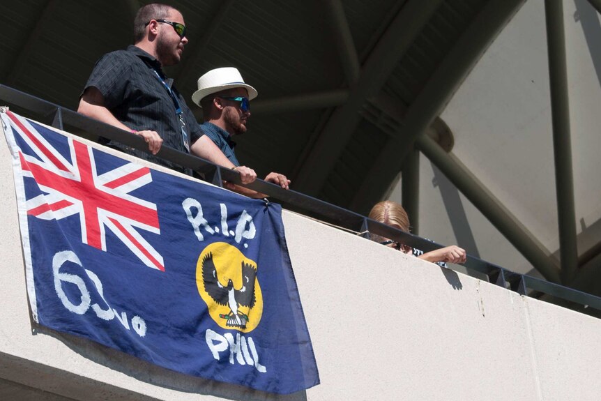 Phillip Hughes fans hang a tribute flag over the balcony of the Chappell Stand.