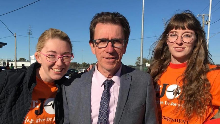 Dr Joe McGirr with two female supporters