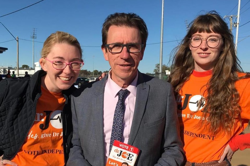Dr Joe McGirr with two female supporters