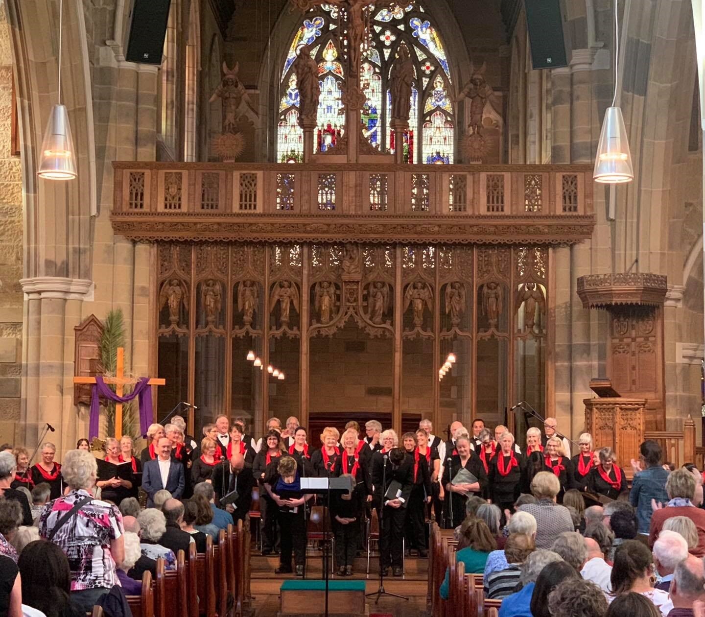 A choir stands in front of an audience in a cathedral 
