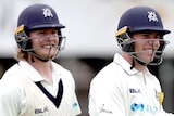 Two Victorian batters walk off the field smiling during a Sheffield Shield match against South Australia.