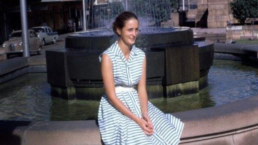 Lois sitting by a fountain.