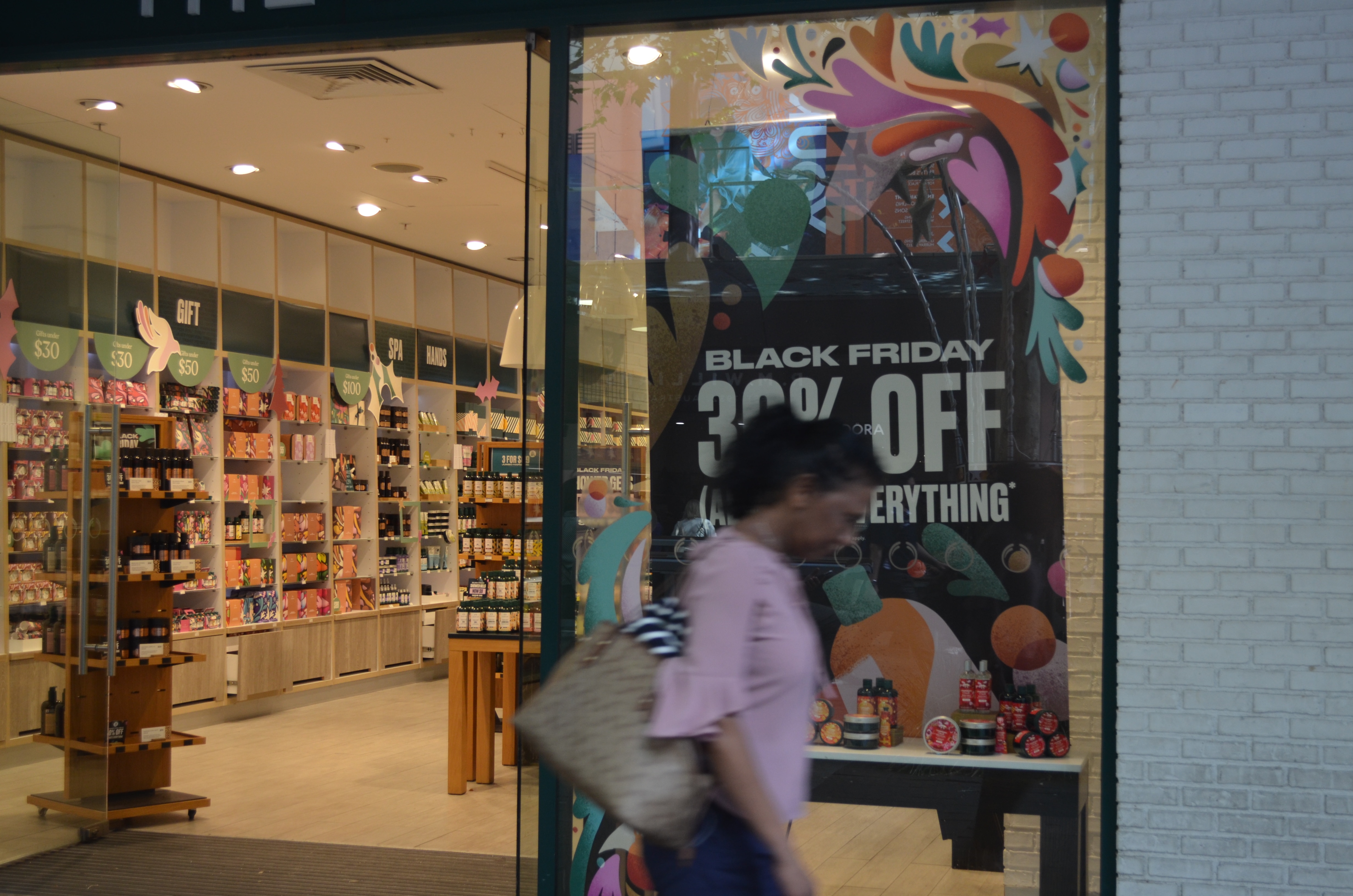 Una mujer pasa por el taller de carrocería en el centro de la ciudad de Perth.