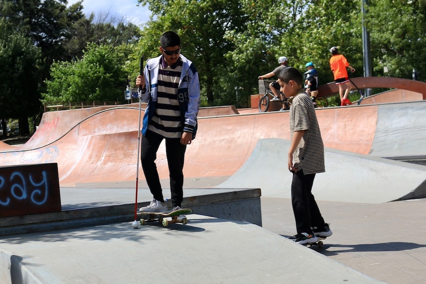 Two boys skateboarding at a skate park. 