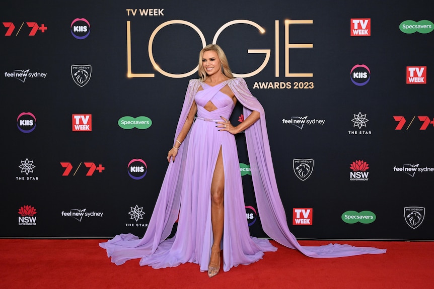 A woman wearing a long, purple gown on the red carpet