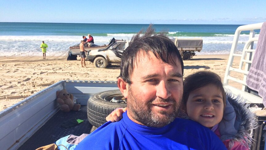 Fifth generation indigenous commercial fishermen Wade Bull with his daughter on a Port Macquarie beach