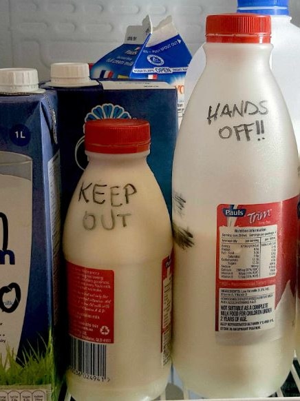 Bottles of milk with KEEP OUT, HANDS OFF AND BREAST MILK? written on them