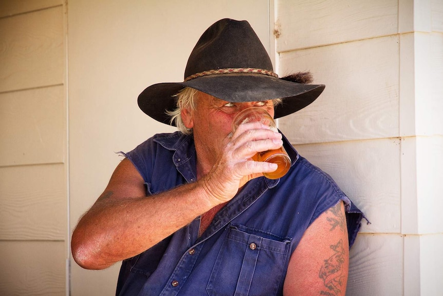 Victorian retiree John Lillico drinks a beer in his new home town of Muttaburra in central-west Queensland