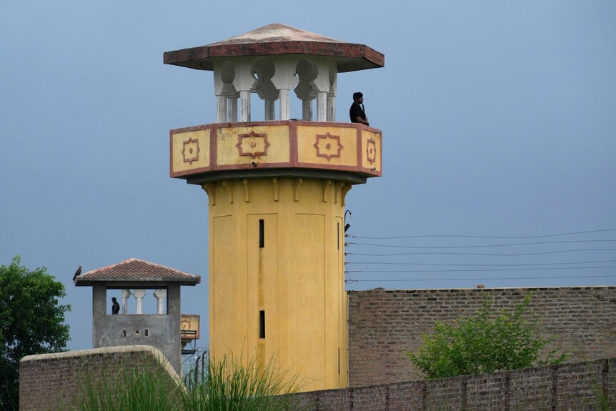 Police officers stand guard on the watch towers of district prison Attock.