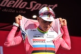 Remco Evenepoel pulls on a pink jersey