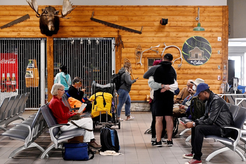 Des gens sont assis dans un salon d’aéroport 