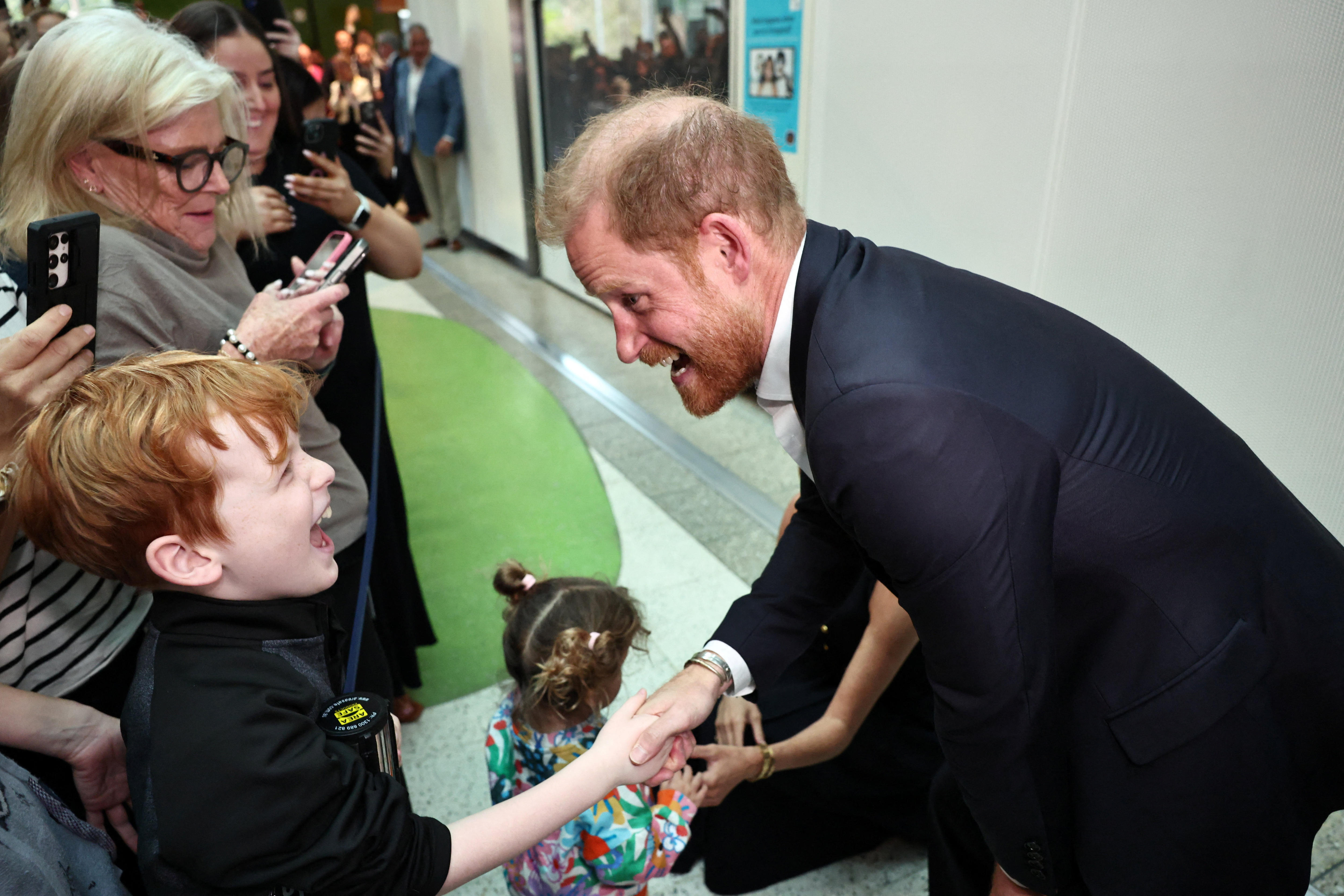 Prince Harry greets a boy as he visits the Royal Children's Hospital in Melbourne.