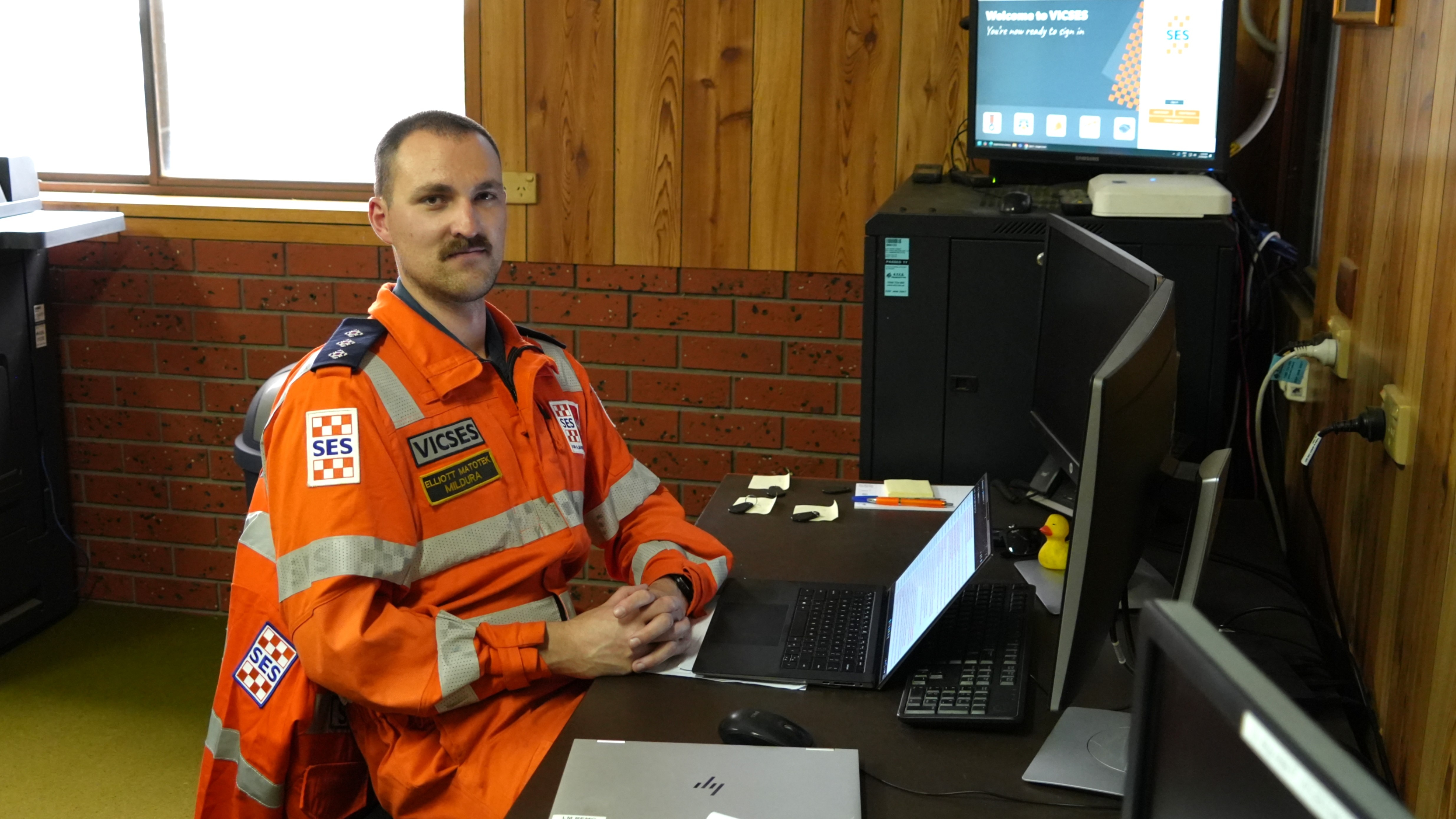 A man in SES uniform sitting in front of a desk