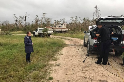 Allyson Horn recording to camera as she stands in long grass in Proserpine