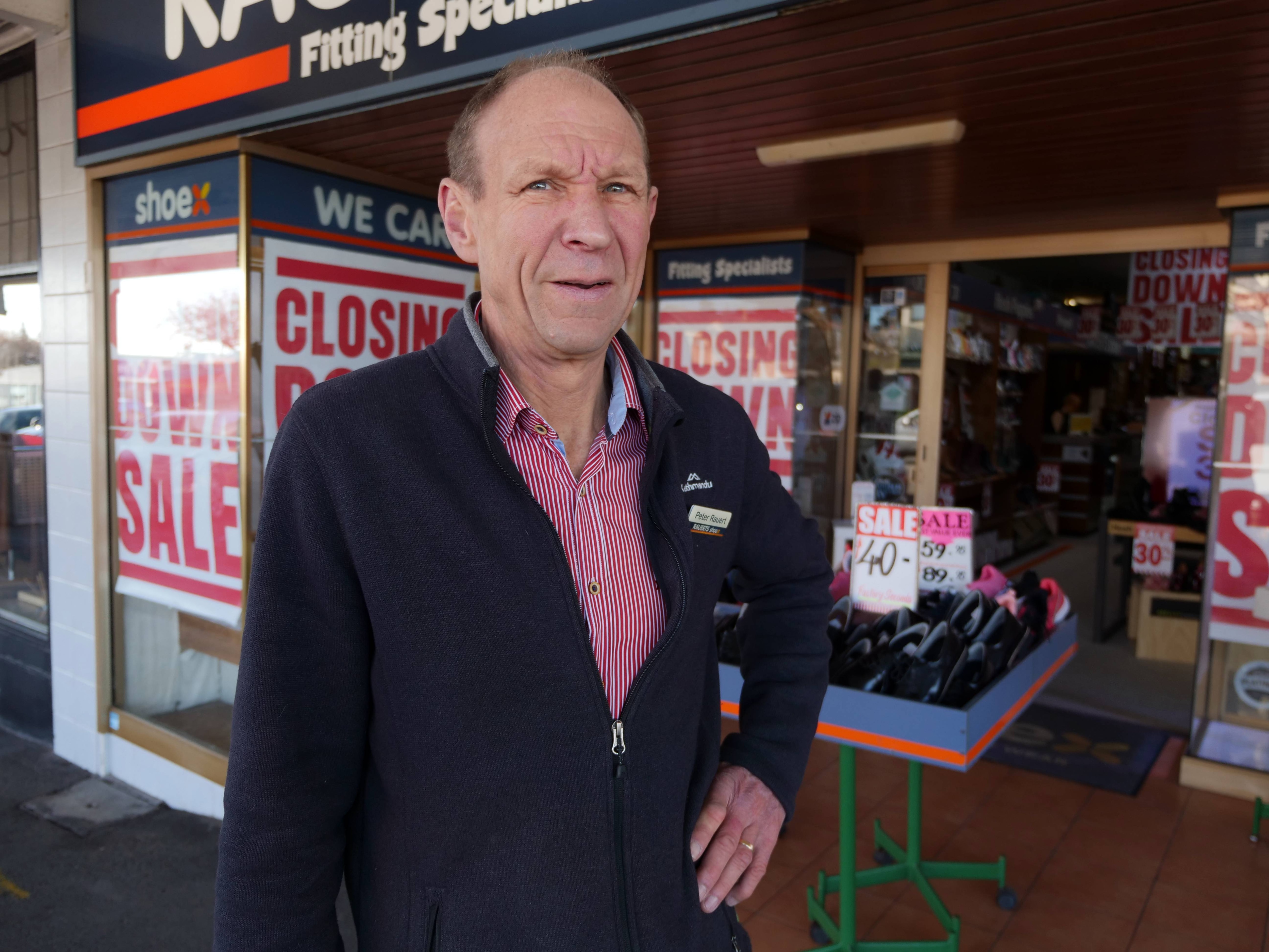 Un hombre fuera de una zapatería.