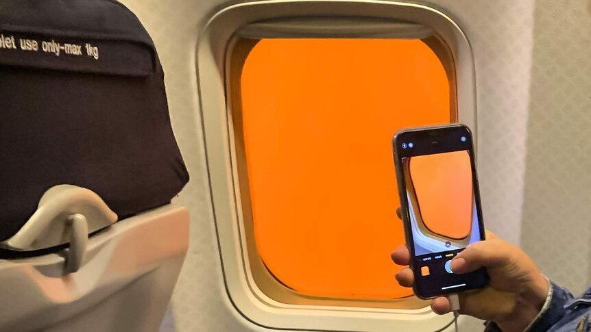 A planes window filled with bright orange.