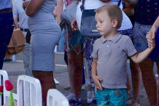 On the Promenade de Anglais in Nice, a toddler looks at a memorial.