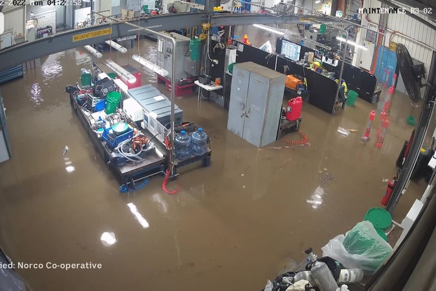 The inside of a factory with the flood covered by brown water.