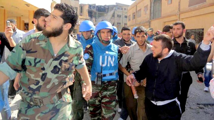 Syrian opposition figure Abdul Razzaq Tlass shows a Moroccan UN observer around the Syrian city of Homs.