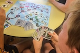 young students playing a card game