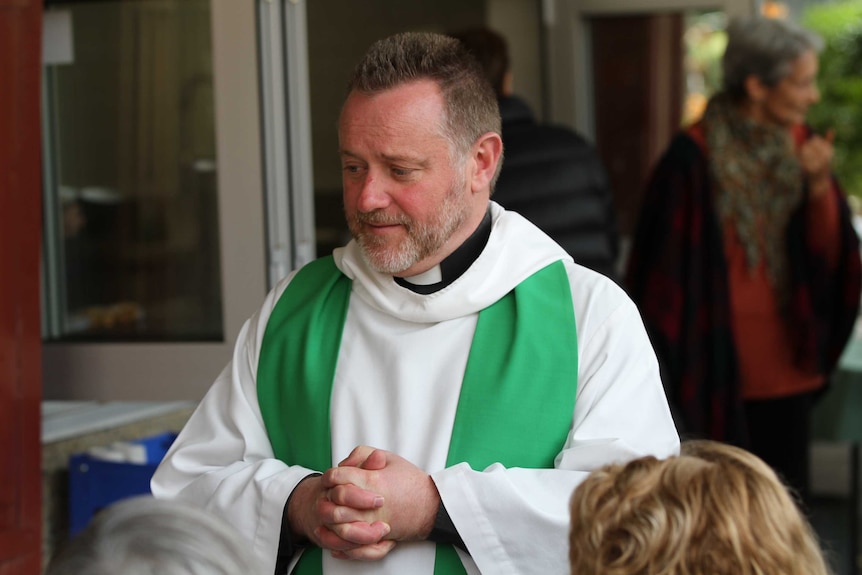 Father Rod Bower speaks with parishioners.