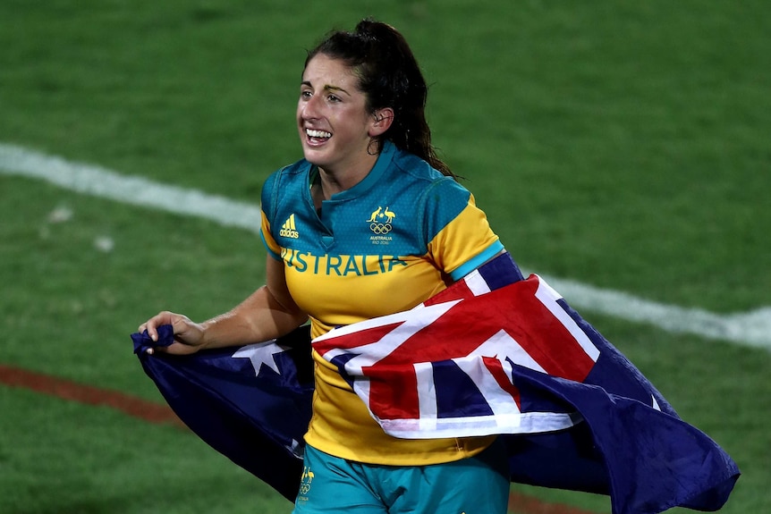 Emilee Cherry with the Australian flag after winning rugby sevens gold